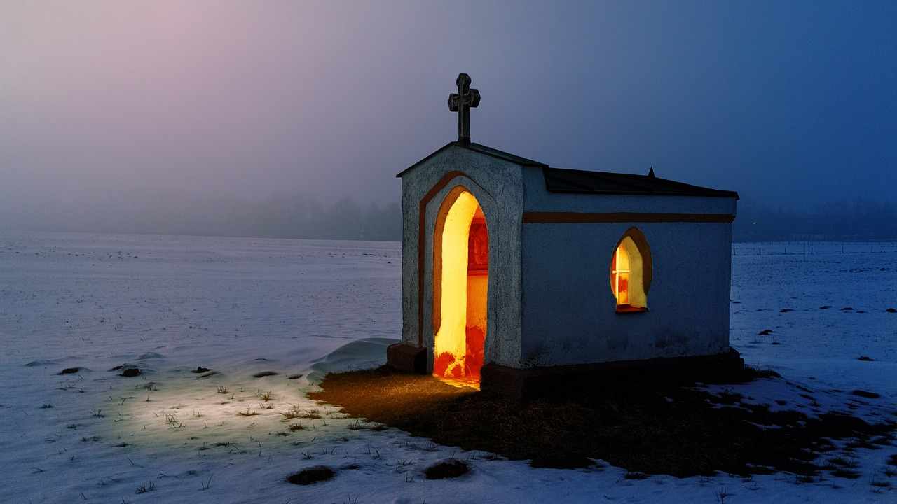 A church at night with the lights on.